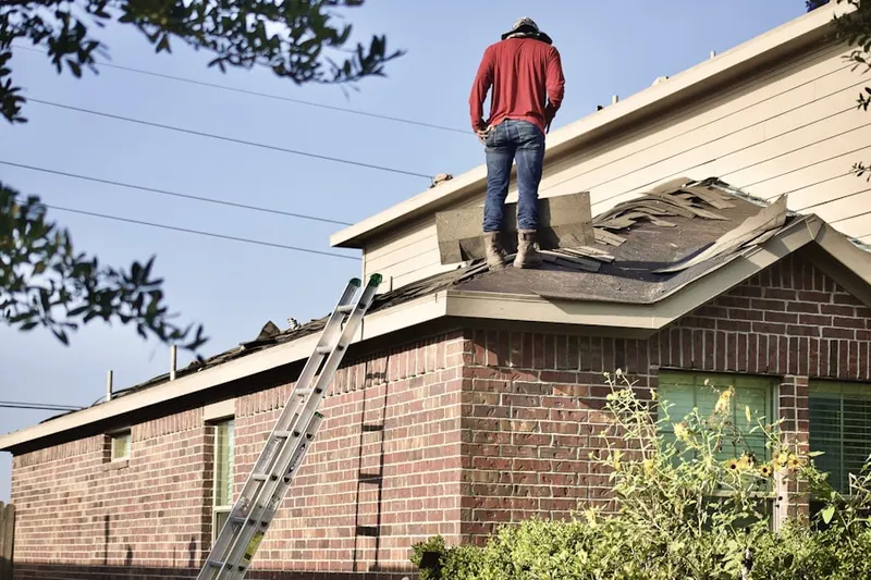 Professional roofer working on a residential roof in Raleigh West